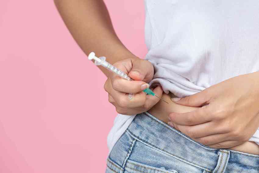Žena si aplikuje inzulinovou injekci.
